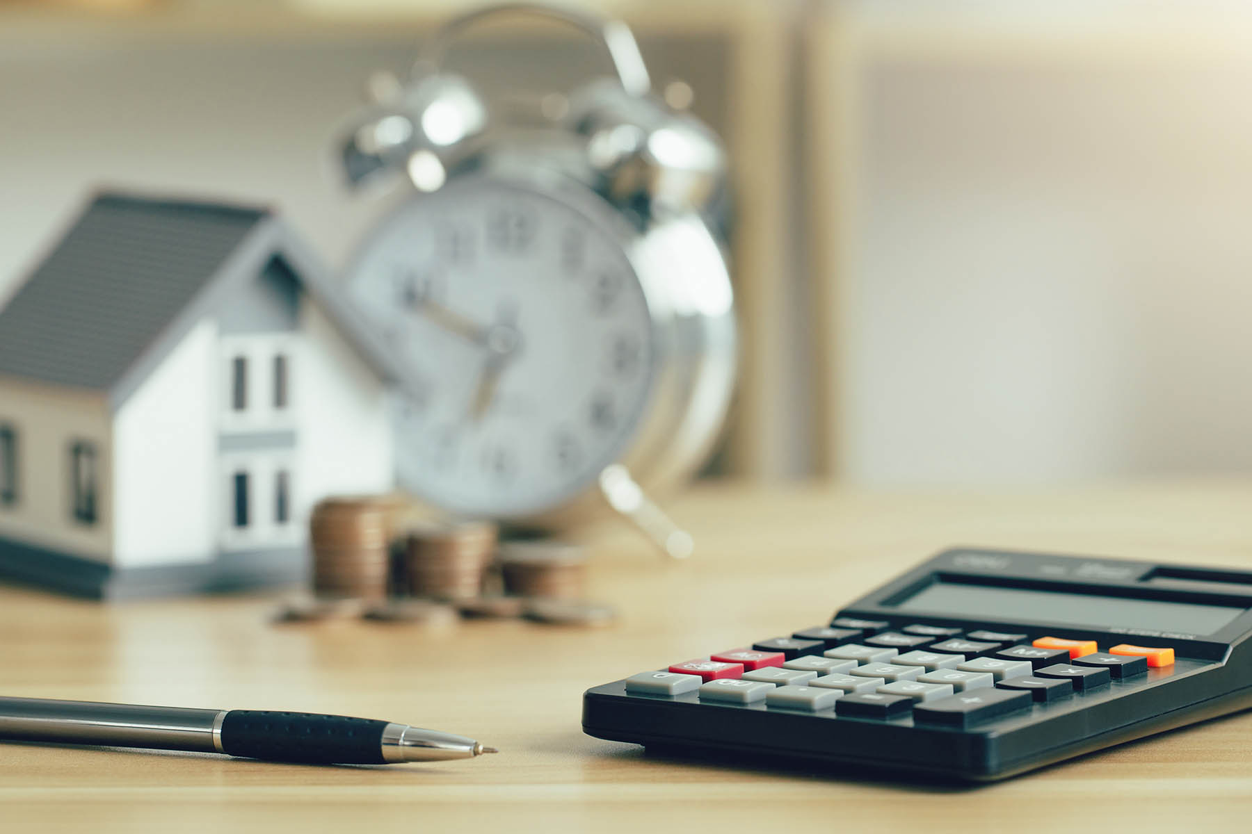 Investor of real estate.Calculator and pen with wooden home model and coins stack and clock. Property investment and house mortgage financial concept. fund finance and interest rate home loan.
